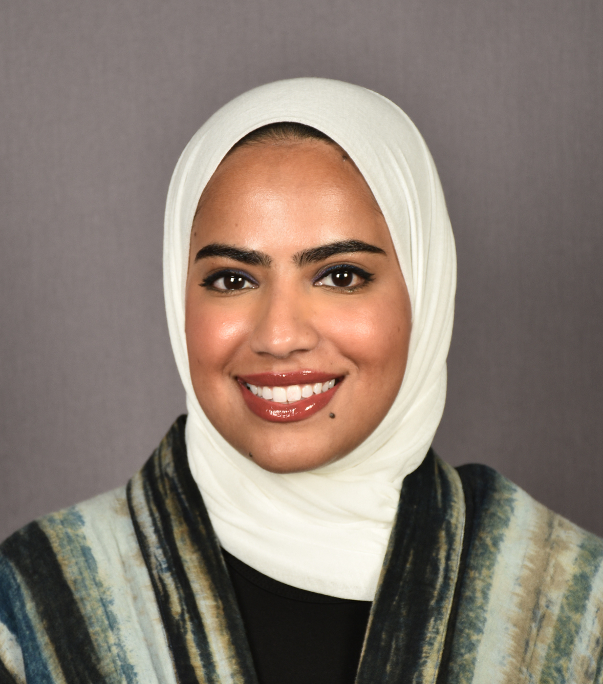 Headshot image of Dr. Mariam Alkheder, a pediatric dentist and assistant professor, wearing formal attire against a neutral background
